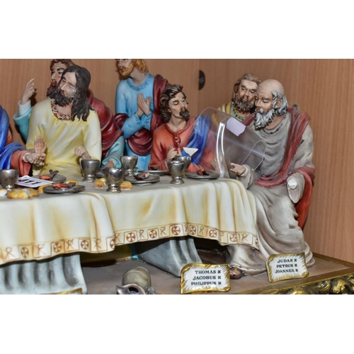 411 - A CAPODIMONTE FIGURE GROUP OF THE LAST SUPPER BY CORTESE, mounted on a giltwood base, marked towards... 