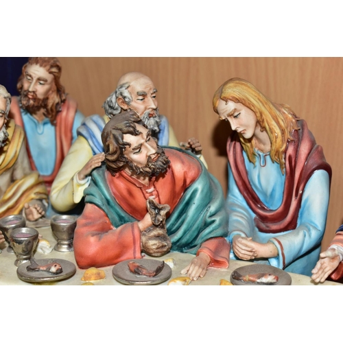 411 - A CAPODIMONTE FIGURE GROUP OF THE LAST SUPPER BY CORTESE, mounted on a giltwood base, marked towards... 