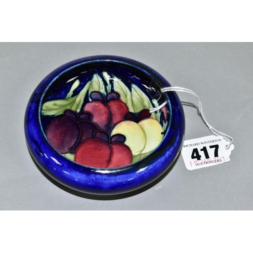 417 - A MOORCROFT POTTERY LIPPED BOWL, the interior decorated with Wisteria (plums) on a blue ground, impr... 