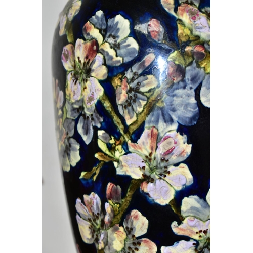 421 - A DOULTON LAMBETH FAIENCE BALUSTER VASE DECORATED BY MARY BUTTERTON, the dark blue ground painted wi... 