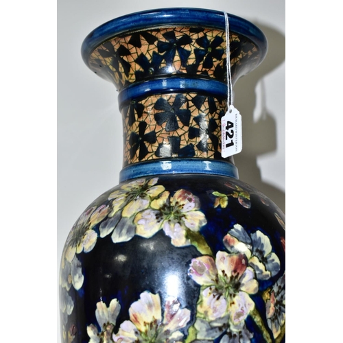 421 - A DOULTON LAMBETH FAIENCE BALUSTER VASE DECORATED BY MARY BUTTERTON, the dark blue ground painted wi... 