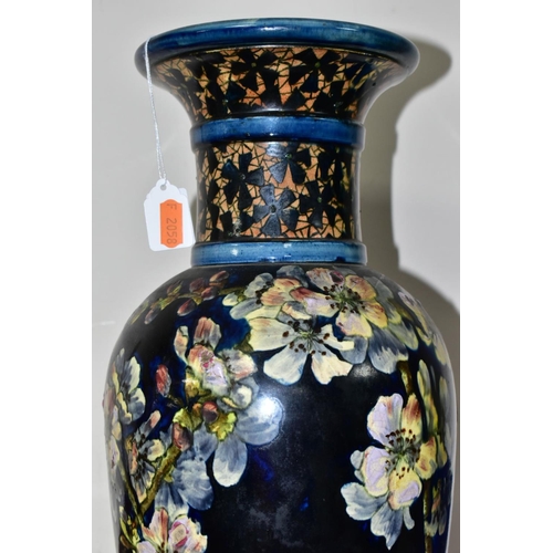 421 - A DOULTON LAMBETH FAIENCE BALUSTER VASE DECORATED BY MARY BUTTERTON, the dark blue ground painted wi... 