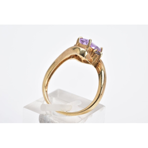 8 - A 9CT GOLD AMETHYST RING, of cross over design, set with a central rectangular cut amethyst flanked ... 