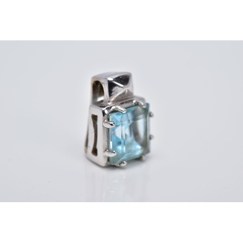 106 - A WHITE METAL BLUE TOPAZ PENDANT, of a square shape, designed with a claw set square cut blue topaz ... 