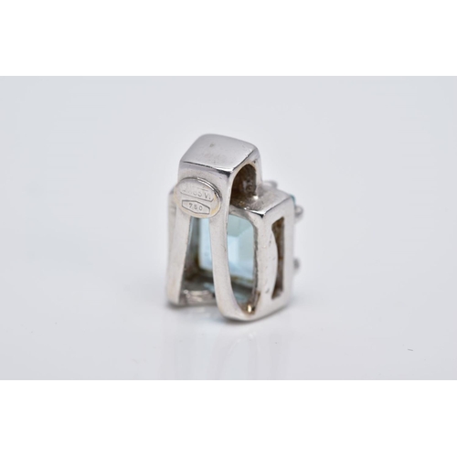 106 - A WHITE METAL BLUE TOPAZ PENDANT, of a square shape, designed with a claw set square cut blue topaz ... 