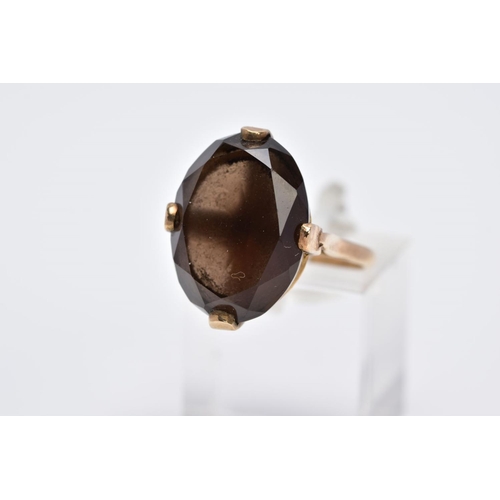 28 - A 9CT GOLD OVAL SINGLE STONE SMOKEY QUARTZ RING, smokey quartz measuring 18.0mm x 13.0mm, ring size ... 