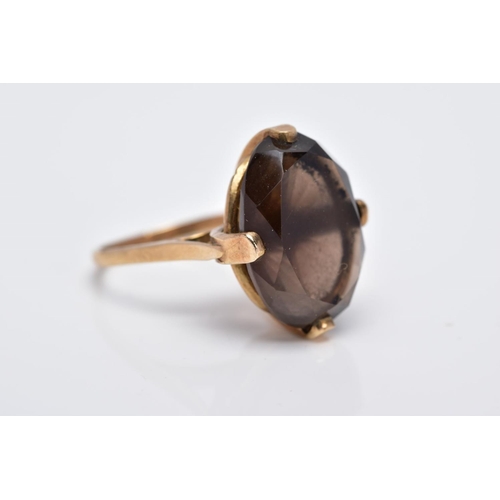 28 - A 9CT GOLD OVAL SINGLE STONE SMOKEY QUARTZ RING, smokey quartz measuring 18.0mm x 13.0mm, ring size ... 