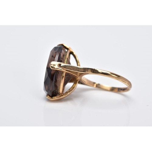 28 - A 9CT GOLD OVAL SINGLE STONE SMOKEY QUARTZ RING, smokey quartz measuring 18.0mm x 13.0mm, ring size ... 