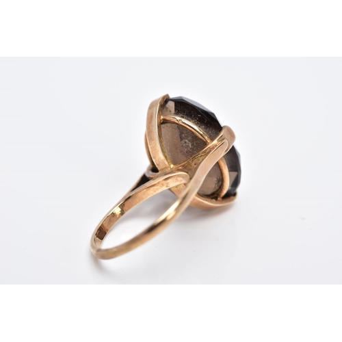 28 - A 9CT GOLD OVAL SINGLE STONE SMOKEY QUARTZ RING, smokey quartz measuring 18.0mm x 13.0mm, ring size ... 