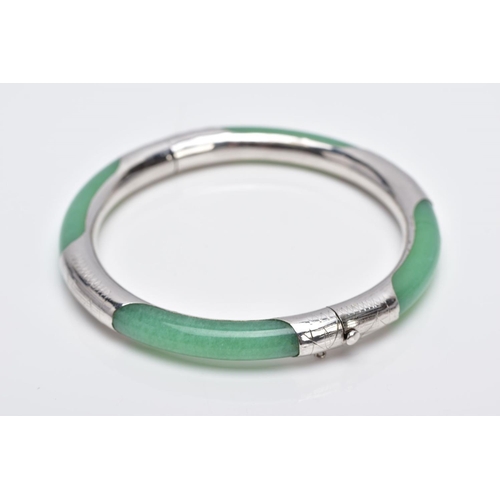 36 - A WHITE METAL AND JADE HINGED BANGLE, jade bangle lined with a decorative white metal lining, fitted... 