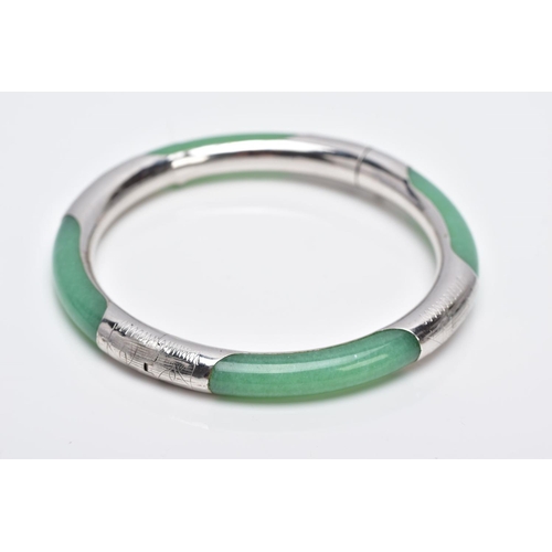 36 - A WHITE METAL AND JADE HINGED BANGLE, jade bangle lined with a decorative white metal lining, fitted... 