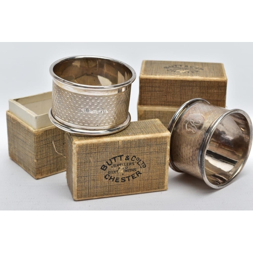 39 - TWO CASED SILVER NAPKIN RINGS each of an engine turn design engraved initial 'E' on one and 'R' on t... 