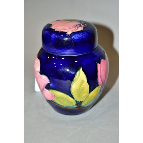 461 - A MOORCROFT GINGER JAR AND COVER, dark blue ground with pink magnolia, impressed marks, height 11cm