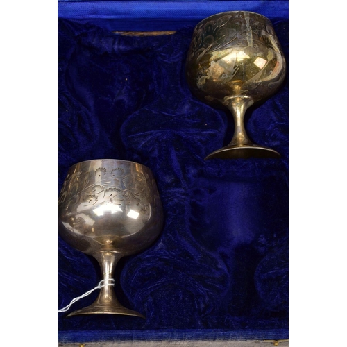 75 - THREE CASED SETS OF WINE AND BRANDY METAL GOBLETS, assorted design each engraved in a foliate and fl... 