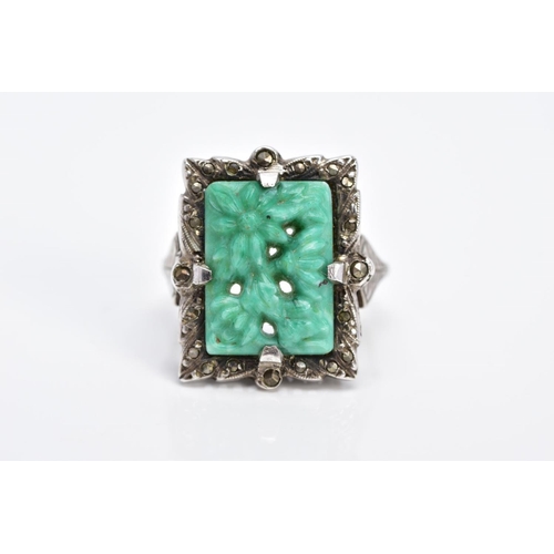 8 - A MARCASITE RING, of rectangular form set with a carved floral green and white central panel within ... 