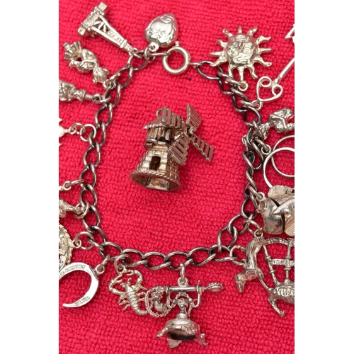 117 - TWO WHITE METAL CHARM BRACELETS AND TWO CHARMS, the first bracelet suspending seventeen charms in fo... 