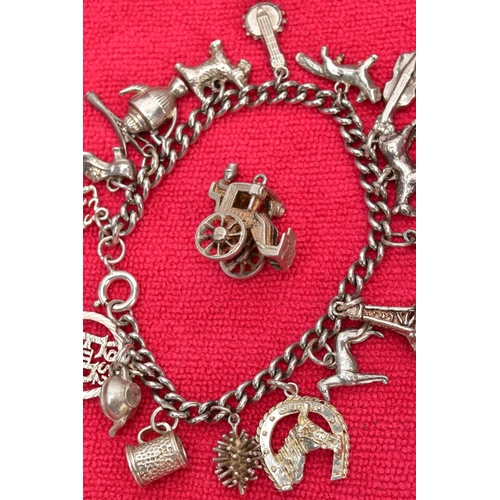 117 - TWO WHITE METAL CHARM BRACELETS AND TWO CHARMS, the first bracelet suspending seventeen charms in fo... 