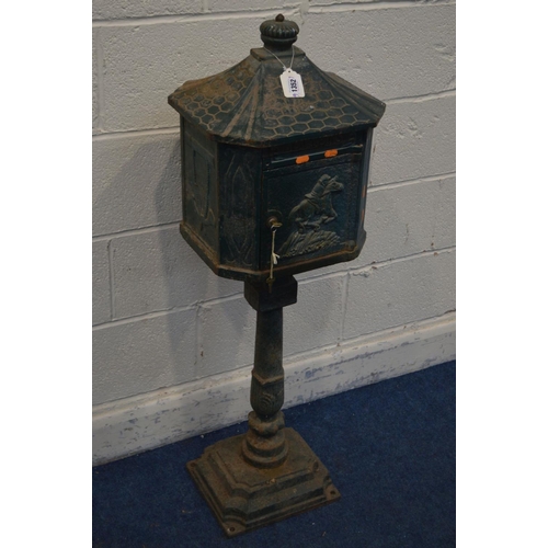 1352 - A GREEN PAINTED CAST IRON LETTER BOX on a stand (one bolt missing between base and pillar) (key)