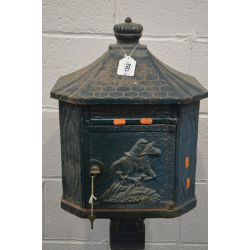 1352 - A GREEN PAINTED CAST IRON LETTER BOX on a stand (one bolt missing between base and pillar) (key)