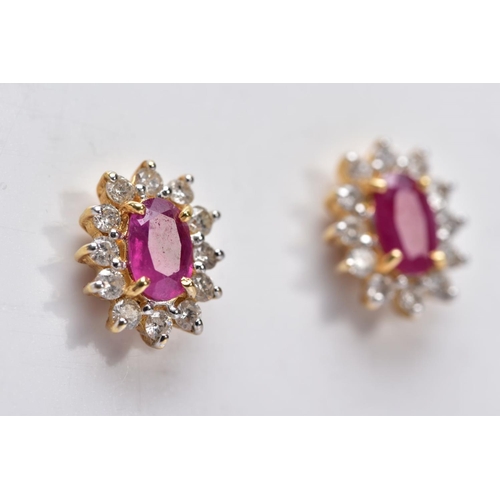 15 - A PAIR OF 18CT GOLD RUBY AND DIAMOND CLUSTER EARRINGS, each designed with a central claw set, oval c... 