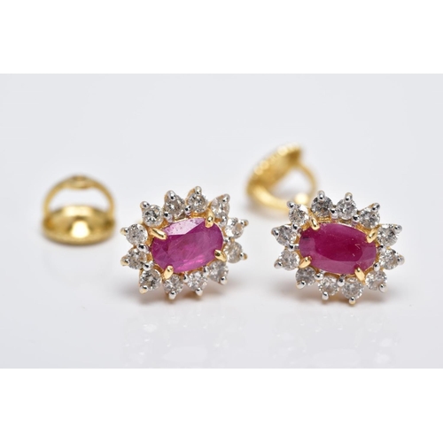 15 - A PAIR OF 18CT GOLD RUBY AND DIAMOND CLUSTER EARRINGS, each designed with a central claw set, oval c... 