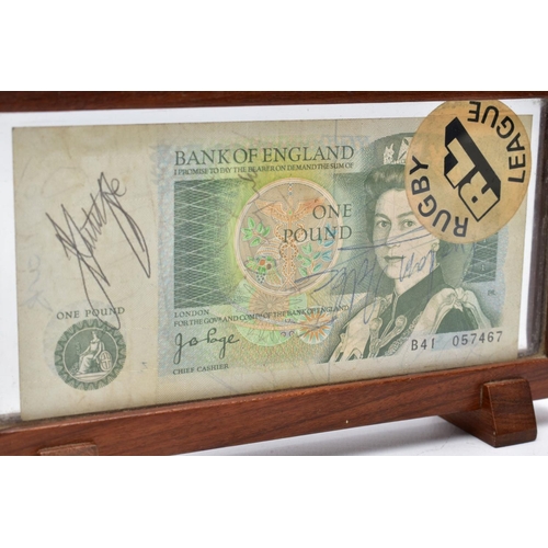 29 - A FRAMED BANK OF ENGLAND 'ONE POUND NOTE', within a wooden frame, raised on two block feet, the note... 