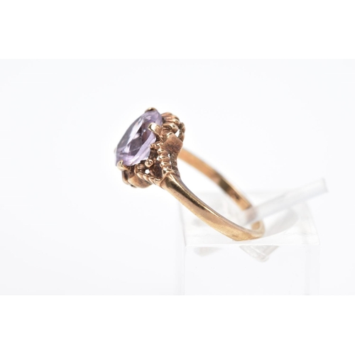 31 - A 9CT GOLD AMETHYST RING, designed with a central claw set, oval cut amethyst within a bead and scal... 