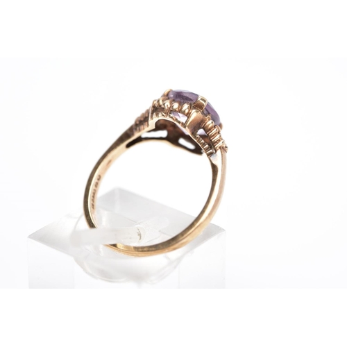 31 - A 9CT GOLD AMETHYST RING, designed with a central claw set, oval cut amethyst within a bead and scal... 