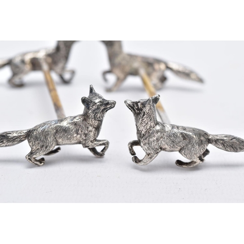 32 - A PAIR OF WHITE METAL KNIFE RESTS, each rest modelled with two foxes to each end with a worn gilt re... 