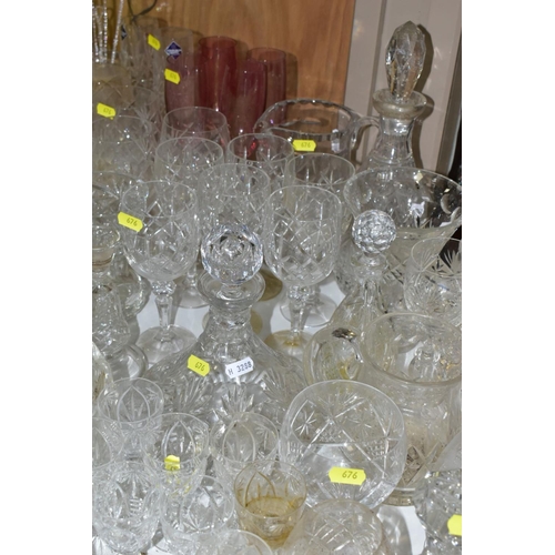 676 - A QUANTITY OF GLASSWARE, including drinking glasses, bowls, jugs, decanters, rose bowls, vases, perf... 