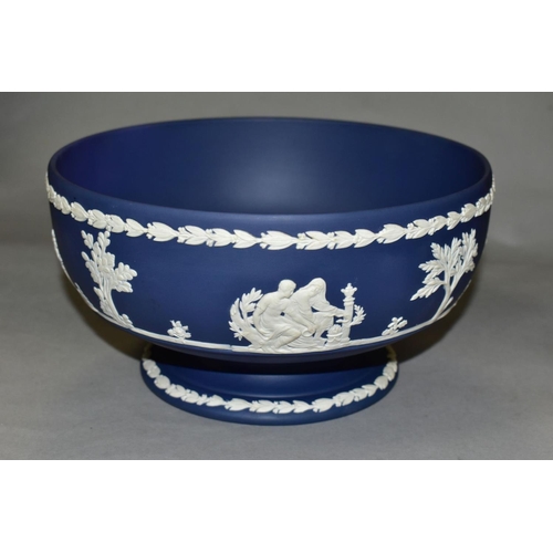 696 - A WEDGWOOD DARK BLUE JASPERWARE PEDESTAL FRUIT BOWL, the applied decoration of classical figures in ... 