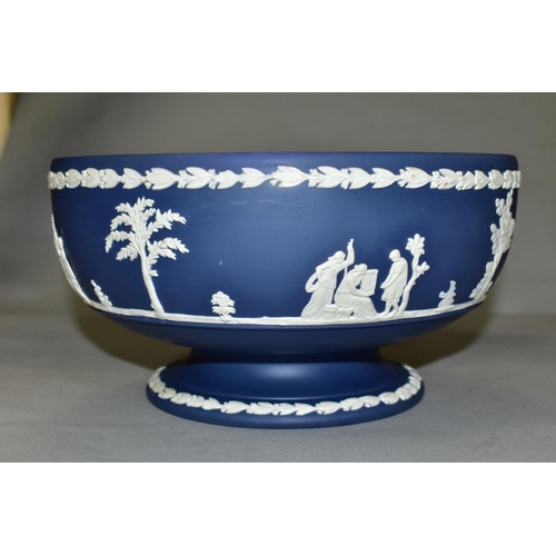 696 - A WEDGWOOD DARK BLUE JASPERWARE PEDESTAL FRUIT BOWL, the applied decoration of classical figures in ... 