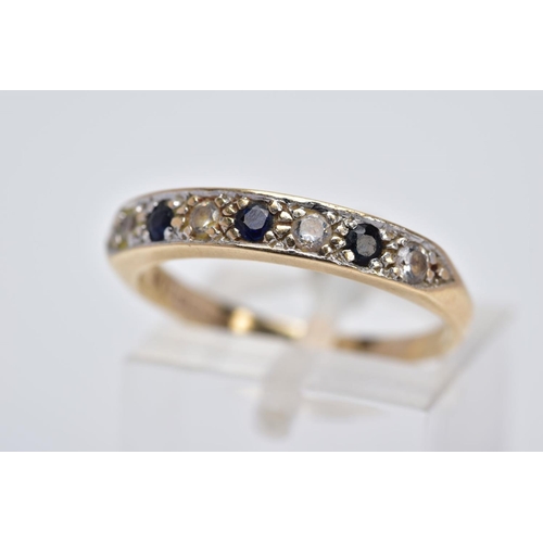 17 - A 9CT GOLD SAPPHIRE AND CUBIC ZIRCONIA HALF HOOP RING, designed with a row of three circular cut blu... 