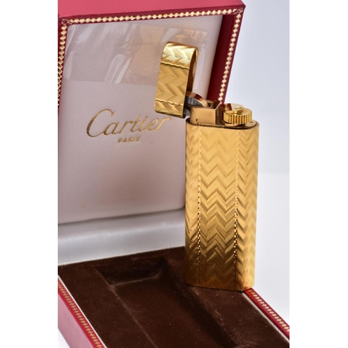 49 - A CARTIER GOLD PLATED LIGHTER, oval rectangular form with engine turned engraving decoration, signed... 