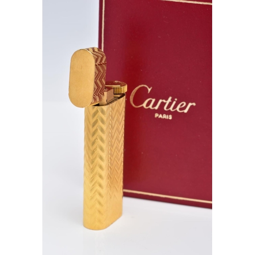 49 - A CARTIER GOLD PLATED LIGHTER, oval rectangular form with engine turned engraving decoration, signed... 