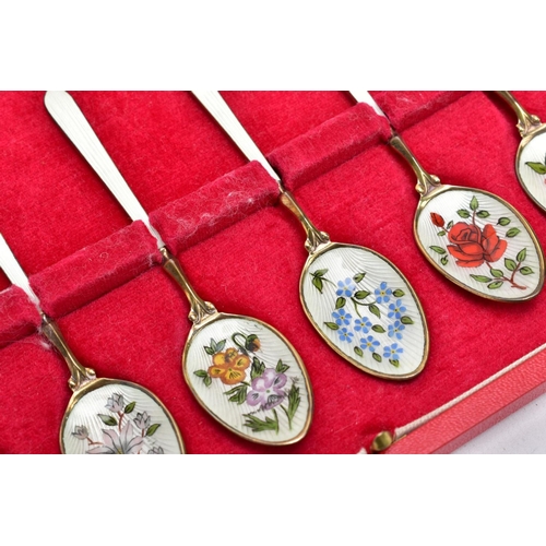 67 - A CASED SET OF SIX SILVER ENAMELLED COFFEE SPOONS, each silver gilt spoon has a decorative floral en... 