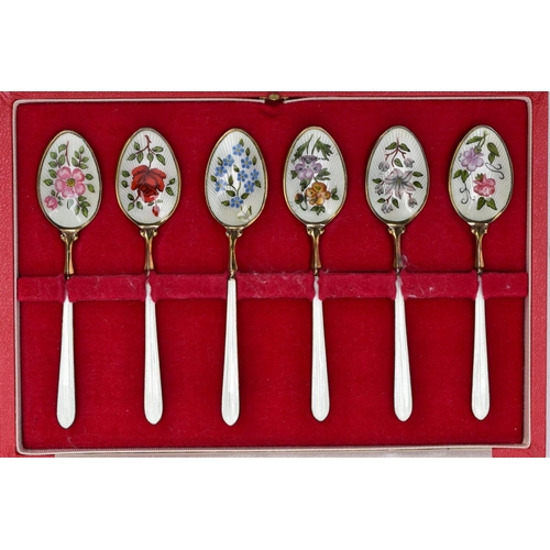 67 - A CASED SET OF SIX SILVER ENAMELLED COFFEE SPOONS, each silver gilt spoon has a decorative floral en... 