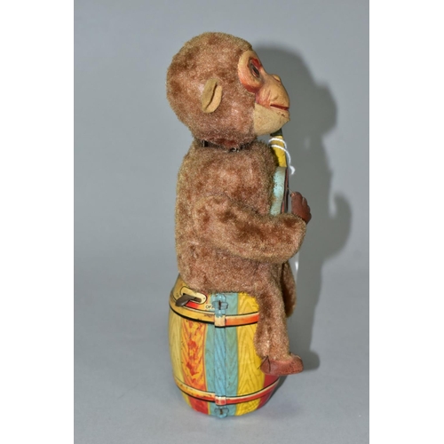 A CLOCKWORK MONKEY PLAYING A GUITAR, nylon plush monkey with plastic face, rubber hands and feet, pl A CLOCKWORK MONKEY PLAYING A GUITAR, nylon plush monkey with plastic face, rubber hands and feet, pl