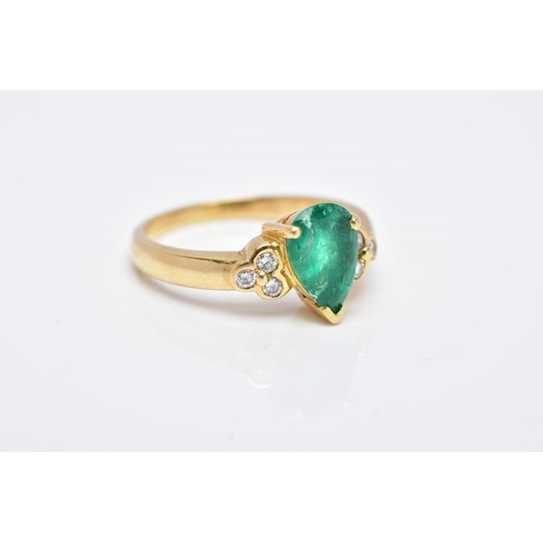 41 - A YELLOW METAL EMERALD AND DIAMOND RING, designed with a central claw set, pear cut emerald, flanked... 