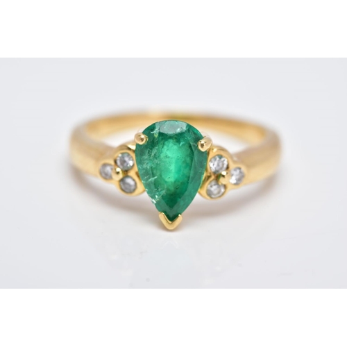 41 - A YELLOW METAL EMERALD AND DIAMOND RING, designed with a central claw set, pear cut emerald, flanked... 