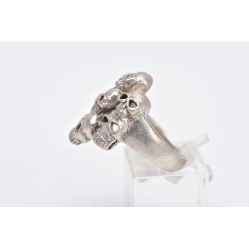 108 - A GENTS WHITE METAL SKULL RING, designed with seven pierced skulls, stamped '925', ring size O, appr... 