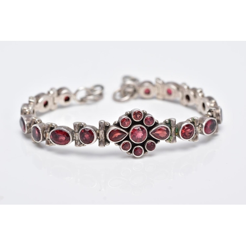 111 - A WHITE METAL, GARNET SET LINE BRACELET, articulated bracelet, designed with a central cluster of ro... 