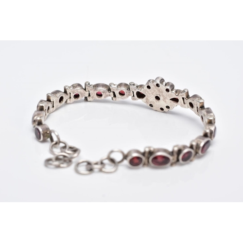 111 - A WHITE METAL, GARNET SET LINE BRACELET, articulated bracelet, designed with a central cluster of ro... 