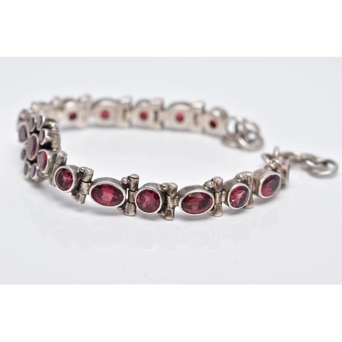 111 - A WHITE METAL, GARNET SET LINE BRACELET, articulated bracelet, designed with a central cluster of ro... 