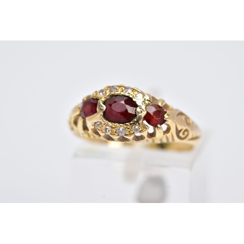 113 - AN 18CT GOLD GARNET AND DIAMOND GYPSY RING, designed with a central oval cut garnet, flanked with ci... 