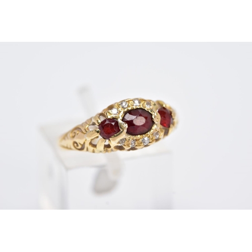 113 - AN 18CT GOLD GARNET AND DIAMOND GYPSY RING, designed with a central oval cut garnet, flanked with ci... 