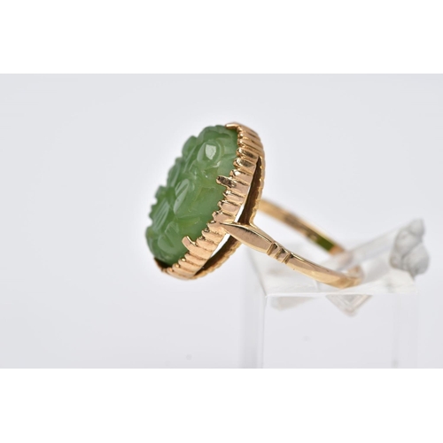 13 - A 9CT GOLD, CARVED NEPHRITE CAMEO RING, of an oval form with a carved floral design, beaded surround... 
