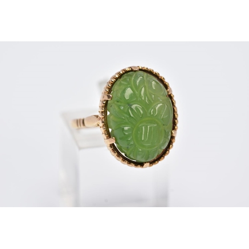 13 - A 9CT GOLD, CARVED NEPHRITE CAMEO RING, of an oval form with a carved floral design, beaded surround... 