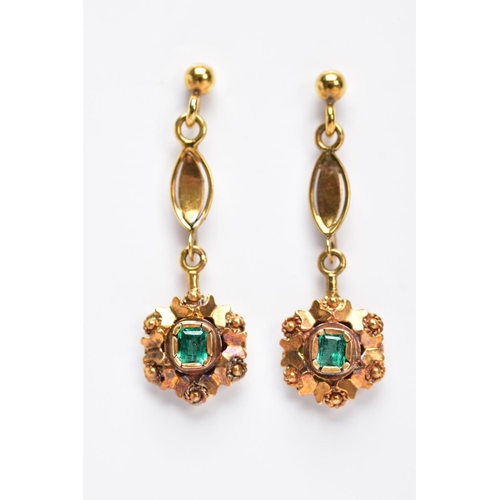 68 - A PAIR OF YELLOW METAL, EMERALD SET DROP EARRINGS, each suspending an emerald cut emerald within a d... 
