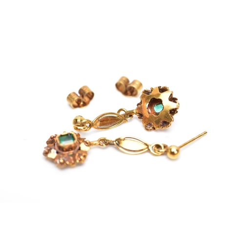 68 - A PAIR OF YELLOW METAL, EMERALD SET DROP EARRINGS, each suspending an emerald cut emerald within a d... 